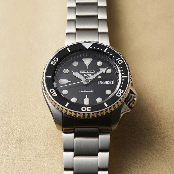 Réf : SRPD55K1  Cette montre Seiko 5 est parfaite pour exprimer votre esprit sportif. Ce garde-temps au cadran noir est équipée d'une lunette rotative graduée ainsi que d'un fond de boîte transparent qui vous permettra d'admirer son calibre automatique.  CARACTERISTIQUES :   Calibre : 4R36 Mouvement : Automatique Index/Aiguilles : Spécificité Lumibrite Boîtier/lunette : Matière Acier inoxydable Étanchéité : 10 ATM Garantie : 2 ans constructeur (internationale)