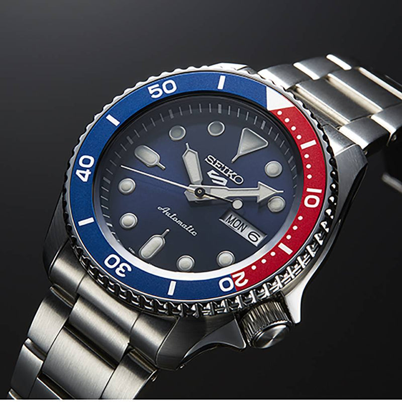 Réf : SRPD53K1  Cette montre automatique fait partie des versions les plus sportives de la nouvelle collection Seiko 5. Complètement en acier inoxydable, ce garde-temps est équipée d'une lunette graduée bleu et rouge. Son cadran bleu est marqué du nouveau logo 5 à 12 heures.   CARACTERISTIQUES :   Calibre : 4R36 Index/Aiguilles : Spécificité Lumibrite Boîtier/Lunette : Matière Acier inoxydable Étanchéité : 10 ATM Garantie : 2 ans constructeur (internationale)