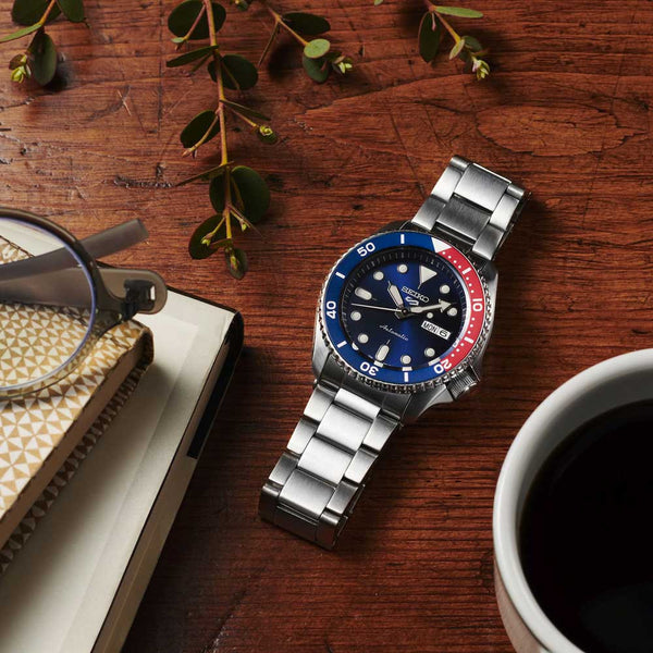 Réf : SRPD53K1  Cette montre automatique fait partie des versions les plus sportives de la nouvelle collection Seiko 5. Complètement en acier inoxydable, ce garde-temps est équipée d'une lunette graduée bleu et rouge. Son cadran bleu est marqué du nouveau logo 5 à 12 heures.   CARACTERISTIQUES :   Calibre : 4R36 Index/Aiguilles : Spécificité Lumibrite Boîtier/Lunette : Matière Acier inoxydable Étanchéité : 10 ATM Garantie : 2 ans constructeur (internationale)