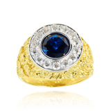 Chevalière ronde sertie d'un zirconium bleu, couronnée de zirconiums, en Or Jaune et Or Blanc 18 Carats- 750/000  La chevalière est le bijou indémodable qui a su traverser les époques pouvant se transmettre de père en fils.   CARACTERISTIQUES :  Diamètre motif central (mm) : 16.18 Poids (gr) : 8.02        Matière : Or 18 Carats - 750/000 20191 